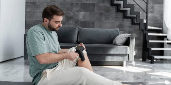 full-shot-man-using-massage-gun